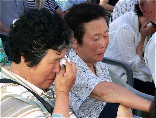 추모시를 들으며 눈물을 흘리고 있는 유족들. 